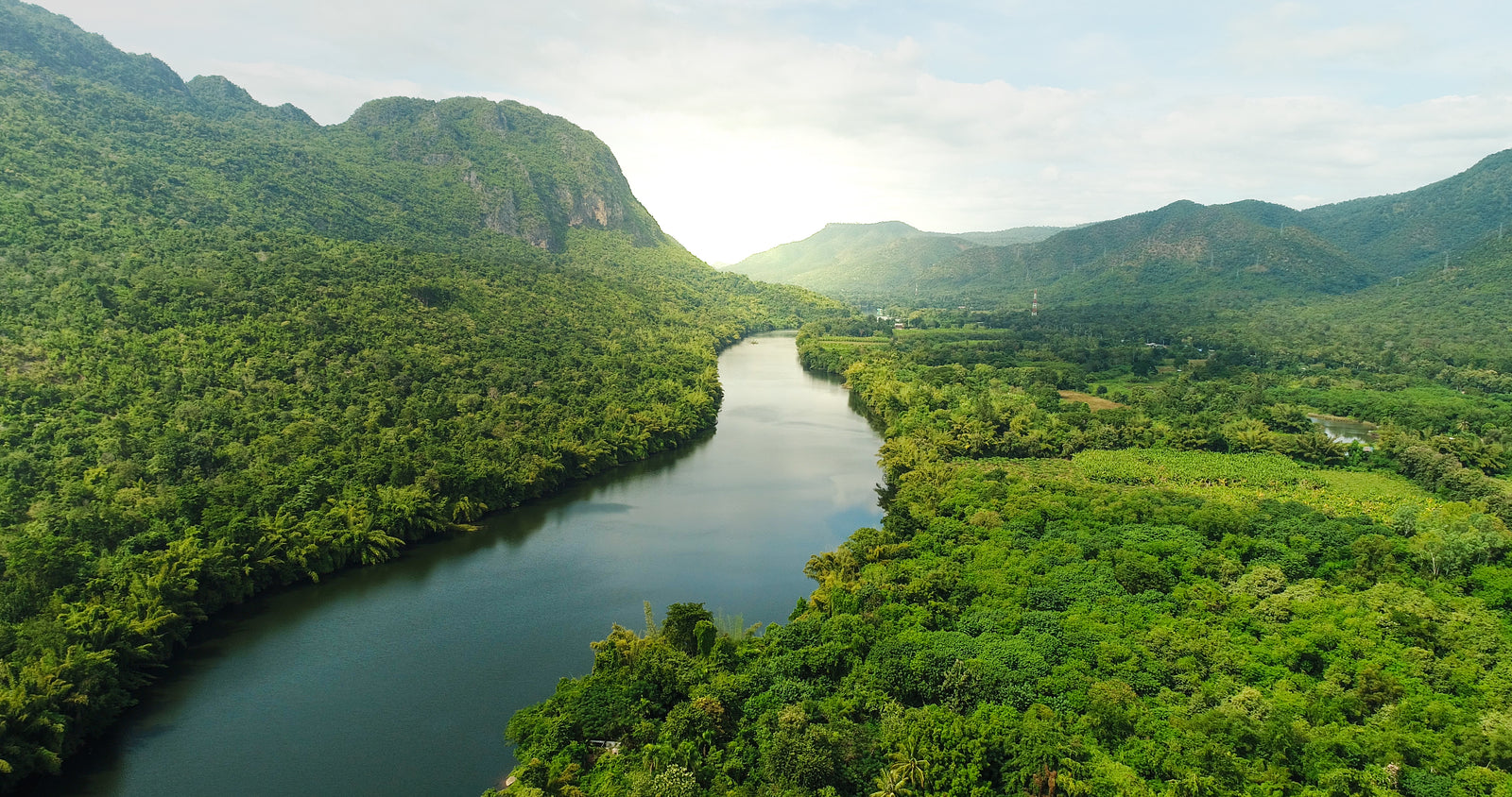 Image of lake running through forest and mountains
